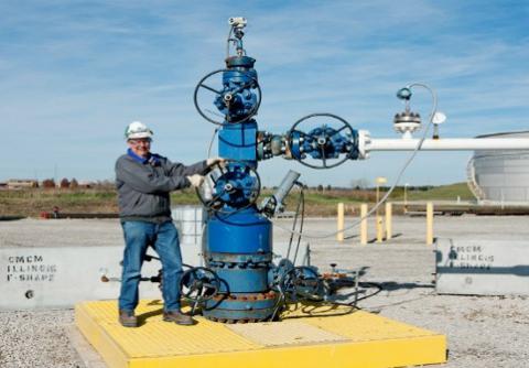 An industry worker making adjustments to large machinery